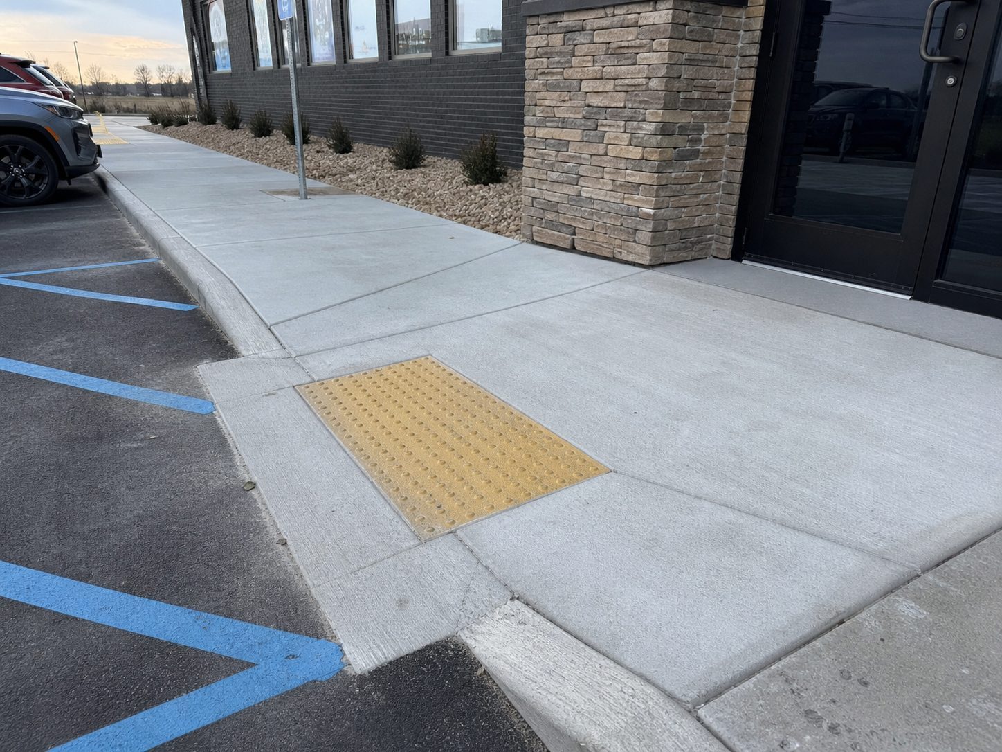 Commercial accessible concrete entry with detectable warning surface and accessible parking area